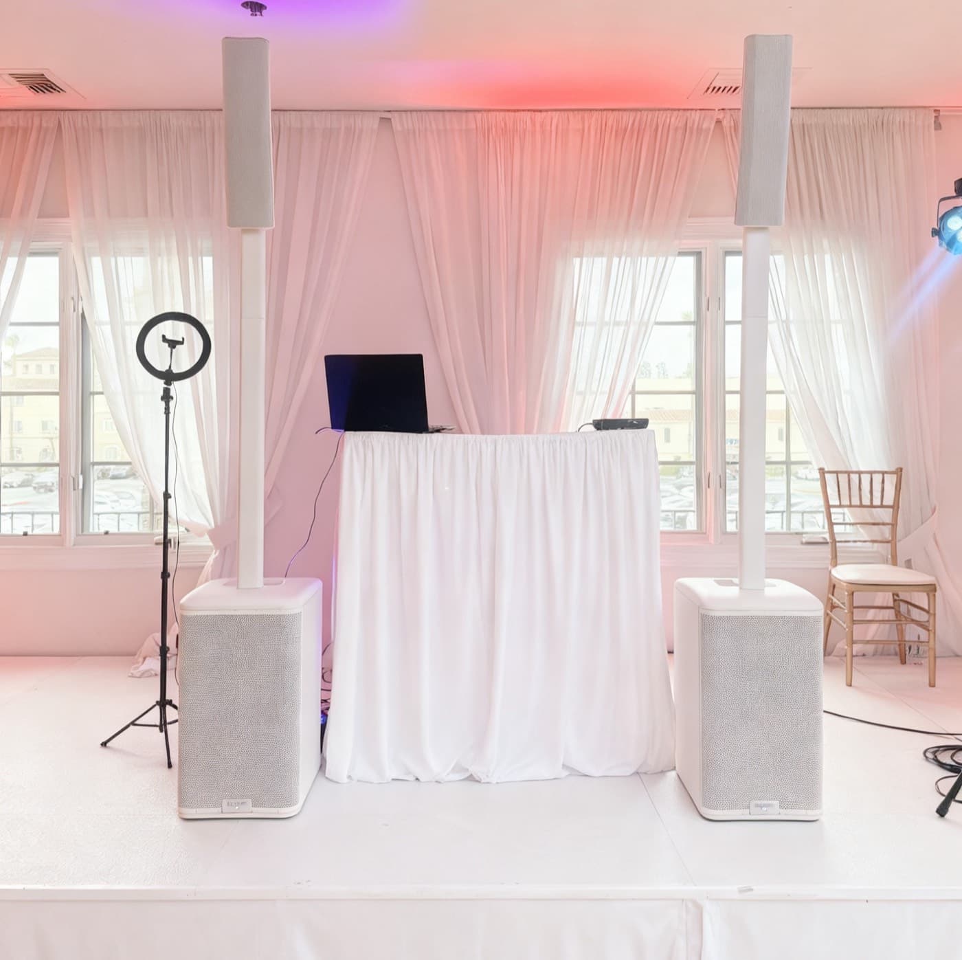 Indoor DJ booth lit in purple and green stage lights with intelligent moving fixtures.