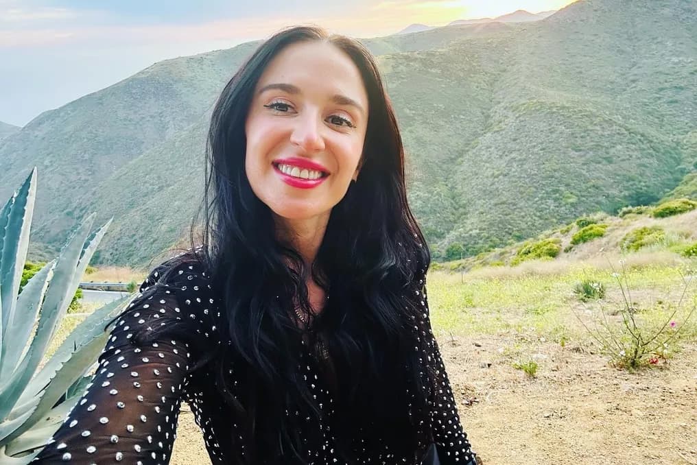 Sunset portrait of Jackie in a sequined black dress, Malibu canyon ridge behind her.